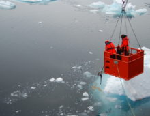 Scientists sample a brown mat of aggregated phytoplankton. (Katrin Schmidt)